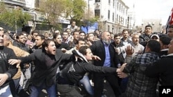Syrians anti and pro-Assad protesters clash after Friday prayers in Damascus, March 25, 2011