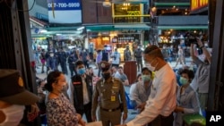 ဘန်ကောက်မြို့ ခေါက်ဆန်လမ်းရှိ ဘားဆိုင်များကို ပိတ်သိမ်းရန် ပြောကြားနေသည့် ထိုင်းတာဝန်ရှိသူအချို့။ (မတ် ၁၈၊ ၂၀၂၀)