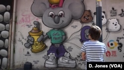 A child observes a mural by one of Istanbul's female artists. Women graffiti artists are increasingly influential in Istanbul’s street art movement.