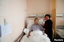 Huang Chenfeng, right, 63, and her husband, Zheng Dingguo, 63, pose for a picture at Fudan University Shanghai Cancer Center in Shanghai, China, Feb. 6, 2018.