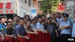 被隔离在济南法院警戒线外面的民众。2013年8月22日(美国之音东方拍摄)