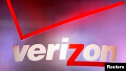 FILE - A Verizon sign is seen displayed at an electronics show.