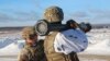 A U.S. instructor trains a Ukrainian soldier how to use a M141 Bunker Defeat Munition (SMAW-D) missile at the Yavoriv military training ground, near Lviv, western Ukraine, Jan. 30, 2022. (Ukrainian Defense Ministry Press Service via AP) 