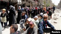 Residents wait to receive food aid south of Damascus, Syria. (May 2014.)