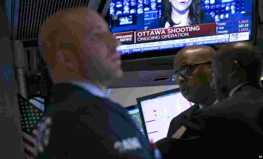 A television on the floor of the New York Stock Exchange features a headline about the shooting in Ottawa. Stocks fell in late afternoon trading on Wednesday, a day after the Standard &amp; Poor&#39;s 500 index had its biggest gain of the year, Oct. 22, 2014. 