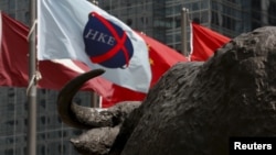 资料照：香港交易广场水牛雕塑前香港证券交易所的旗子在飘扬。（2015年5月28日）