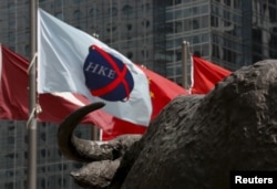 資料照：香港交易廣場水牛雕塑前香港證券交易所的旗在飄揚。 （2015年5月28日）
