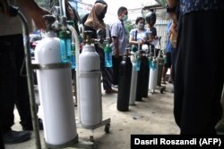 Masyarakat mengantre di toko pengisian oksigen di Jakarta pada 28 Juni 2021, saat infeksi COVID-19 melonjak mencapai rekor tertinggi di Indonesia. (Foto: AFP/Dasril Roszandi)