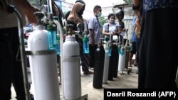 Masyarakat mengantre di toko pengisian oksigen, saat infeksi COVID-19 melonjak mencapai rekor tertinggi di Indonesia. (Foto: AFP/Dasril Roszandi)