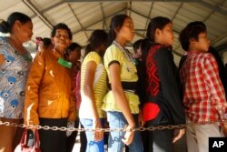 FILE - Cambodian villagers line up to enter a courtroom before the first appeal hearings against two former Khmer Rouge senior leaders, Khieu Samphan and Nuon Chea, at the U.N.-backed war crimes tribunal in Phnom Penh, Cambodia, July 2, 2015.