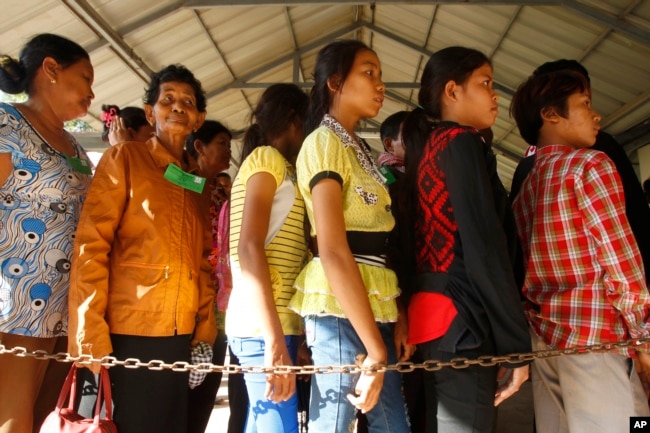 FILE - Cambodian villagers line up to enter a courtroom before the first appeal hearings against two former Khmer Rouge senior leaders, Khieu Samphan and Nuon Chea, at the U.N.-backed war crimes tribunal in Phnom Penh, Cambodia, July 2, 2015.