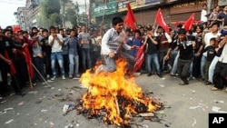 A Unified Communist Party of Nepal (Maoist) supporter jumps over a fire with a burining effigy of prime minister Madhav Kumar Nepal during the fourth day of indefinite strike in Kathmandu, 05 May 2010