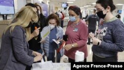 Staff volunteers queue to receive a fourth dose of the Pfizer-BioNTech COVID-19 coronavirus vaccine at the Sheba Medical Center in Ramat Gan near Tel Aviv, on Dec. 27, 2021, as the Israeli hospital conducted a trial of the vaccine's fourth jab on staff vo