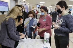 在特拉維夫附近的捨巴醫療中心，員工志願者排隊接種第四針輝瑞-生物科技新冠疫苗。（2021年12月27日)
