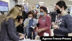 Staff volunteers queue to receive a fourth dose of the Pfizer-BioNTech COVID-19 coronavirus vaccine at the Sheba Medical Center in Ramat Gan near Tel Aviv, on Dec. 27, 2021, as the Israeli hospital conducted a trial of the vaccine's fourth jab on staff vo