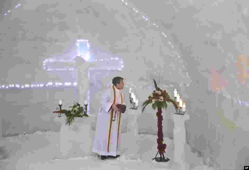 A Romanian priest puts out candles inside a church built entirely from ice blocks cut from a frozen lake after a blessing religious service at the Balea Lac resort in the Fagaras mountains.