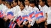 FILE PHOTO - Students from a local high school carry the U.S. national flags and Cambodia's national flags in Siem Reap, Cambodia, Saturday, March 21, 2015. (AP Photo/Wong Maye-E)