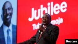 Rais wa Kenya Uhuru Kenyatta akisimama mbele ya bango lililoandikwa jina la chama chake, Jubilee.