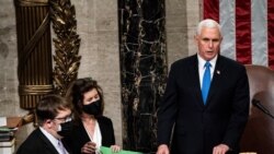 US Vice President Mike Pence (C) arrives to preside over a joint session of Congress counting the electoral votes for President after they resumed the session following protests at the US Capitol in Washington, DC, January 7, 2021. - US lawmakers formally