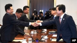 In this photo provided by the South Korea Culture and Sports Ministry, South Korean head delegate Jeon Choong-ryul, right, shakes hands with his North Korean counterpart Won Kil U during a meeting at the southern side of Panmunjom in the Demilitarized Zone, North Korea, June 18, 2018.