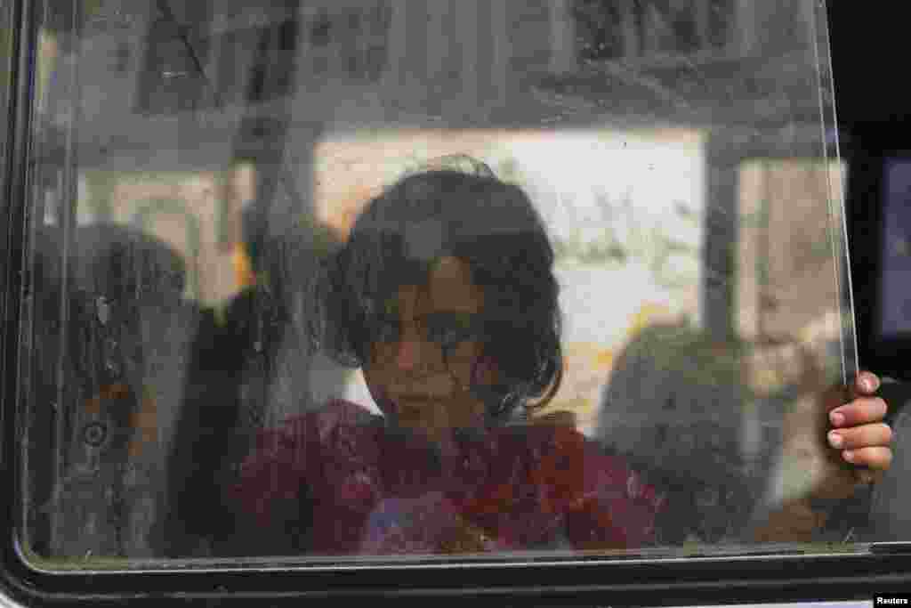 A girl looks through the window of a minibus as her family prepares to leave the Beit Hanoun neighbourhood in Gaza City, August 8, 2014.