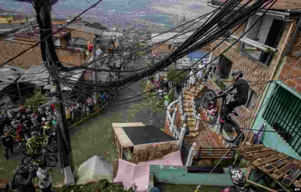 Residents watch as a downhill rider competes during the Urban Bike Inder Medellin race final at the Comuna 1 shantytown in Medellin, Antioquia department, Colombia.