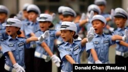 Anak-anak mengenakan seragam polisi lalu lintas di sebuah sekolah dasar di Zhengzhou, China, 17 Mei 2010. China mencabut batasan mengenai banyaknya anak yang diperbolehkan dimiliki satu keluarga dari dua menjadi tiga per pasangan suami istri. (Foto: REUTERS/Donald Chan)