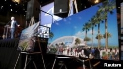 Los Angeles Rams Chief Operating Officer Kevin Demoff speaks behind an illustration of the Rams' planned new stadium at a celebration to welcome NFL team, the Los Angeles Rams, at the Forum in Inglewood, California, Jan. 15, 2016.