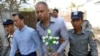 Philip Blackwood, second right, general manager of VGastro Bar, walks with bar owner Tun Thurein, second left, and its manager, Htut Ko Ko Lwin, seen behind Blackwood, upon arrival for their trial at a township court, Feb. 17, 2015.