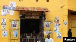 Des hommes sont assis devant les affiches électorales à Beni, dans la province du Nord-Kivu en République démocratique du Congo, le 5 décembre 2018. REUTERS / Goran Tomasevic - RC11CB7A2BB0