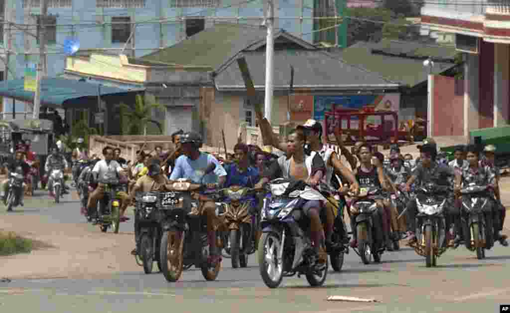 Hundreds of Buddhists on motorcycles armed with sticks patrol in the streets of in Lashio, northern Shan State, Burma. Sectarian violence spread to the northeastern town after unconfirmed rumors spread that a Muslim man had set fire to a Buddhist woman.