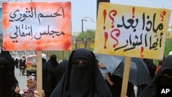 Yemeni anti-government demonstrators holds placards during a protest under the slogan 'Friday of a Civil State' in Sana'a , July 15, 2011