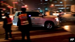An SUV drives past traffic police officers during evening rush hour in Beijing, Dec. 12, 2016. China's explosive demand for SUVs helped boost auto sales 17.2 percent in November over a year ago, an industry group said Monday.
