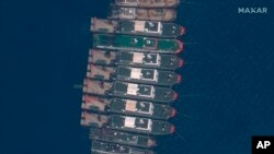 This satellite image provided by Maxar Technologies shows Chinese vessels anchored the Whitsun Reef located in the disputed South China Sea. Tuesday, March 23, 2021. (©2021 Maxar Technologies via AP)