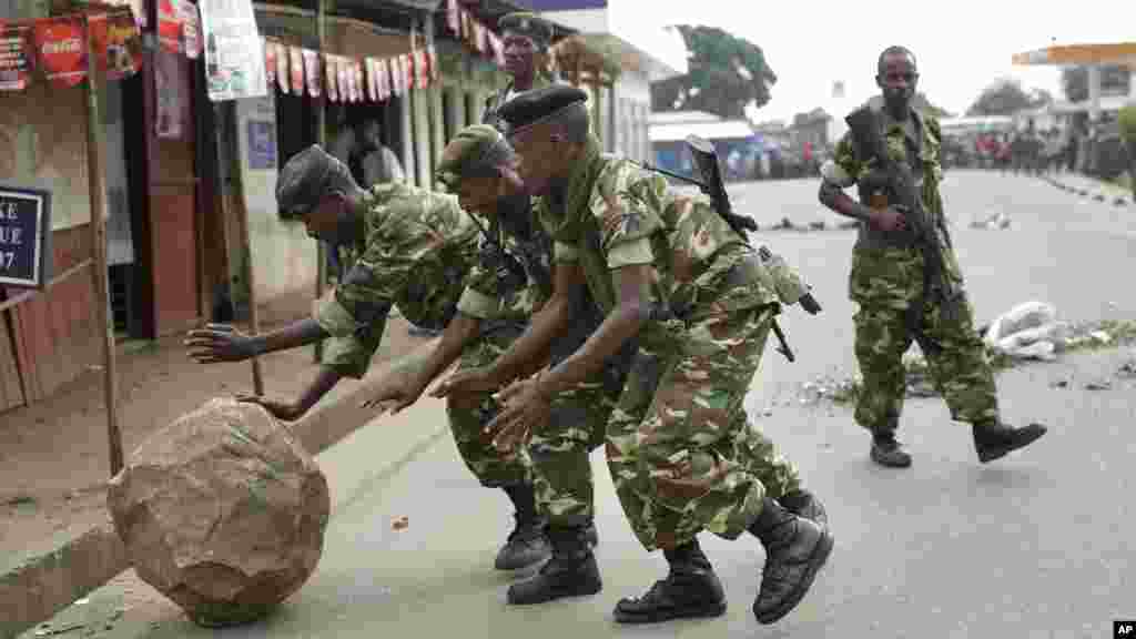 Des soldats roulent un roc que des manifestants ont posé pour bloquer une route à Cibitoke, à Bujumbura, le 22 mai 2015.
