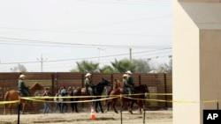 FILE - A group of people are detained by Border Patrol agents on horseback after crossing the border illegally from Tijuana, Mexico, near prototypes for a border wall, right, being constructed in San Diego, Calif., Oct. 19, 2017.