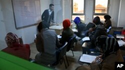 Syrian refugees are seen through a window attending an English language class, at a multi-service center for Syrian refugees in Gaziantep, Turkey, April 22, 2015. 
