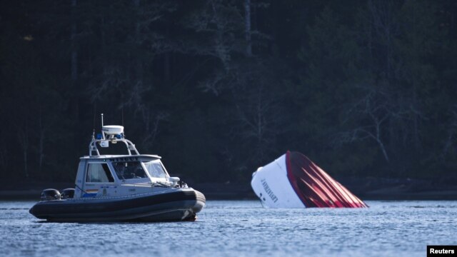 Un bote de la Policía canadiense lleva buzos hasta el lugar donde se hundió el domingo un barco crucero en Tofino, en la Columbia Británica.