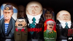 FILE - Russian traditional wooden matryoshka dolls showing Russian President Vladimir Putin and Soviet leader Joseph Stalin, front, are on sale in a street souvenir shop in Moscow, Dec. 2, 2015.