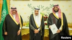 FILE - (L-R) Saudi Crown Prince Mohammed bin Nayef, Saudi King Salman, and Saudi Arabia's Deputy Crown Prince Mohammed bin Salman stand together as Saudi Arabia's cabinet agrees to implement a broad reform plan.