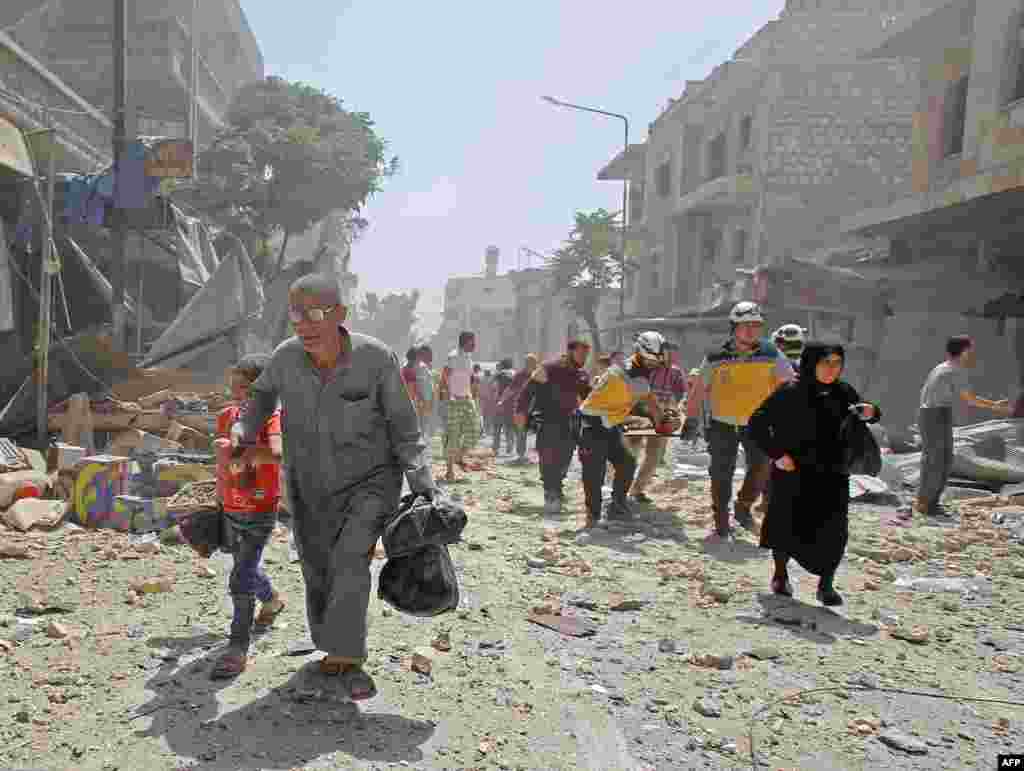 Members of the Syrian Civil Defense (known as the White Helmets) carry a wounded man on a stretcher following a reported airstrike on the town of Maaret al-Numan in the jihadist-held Idlib province.