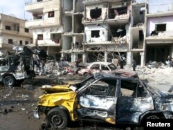 People inspect the site of a two bomb blasts in the government-controlled city of Homs, Syria, in this handout picture provided by SANA on Feb. 21, 2016.