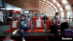 Para penumpang mengenakan masker menunggu giliran masuk ke pesawat Air France untuk penerbangan ke Mexico City di Terminal 2E Bandara Charles de Gaule, Paris, di tengah pandemi virus corona, di Perancis, 6 Mei 2020. (Foto: Benoit Tessier/Reuters)