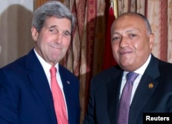 U.S. Secretary of State John Kerry, left, greets Egypt's Foreign Minister Sameh Shoukry in Cairo October 12, 2014.