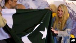 FILE - British-American mountaineer Vanessa O'Brien, right, who holds the Guinness World Record for climbing the Seven Summits in 295 days, receives Pakistani flag from officials during her news conference in Islamabad, Pakistan, June 15, 2017. 