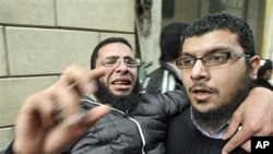 Anti-government protesters carry an injured man during clashes in Cairo's Tahrir Square, February 4, 2011