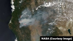 Smoke rising from wildfires burning in Northern California, as taken by NASA satellites, Aug. 6, 2015.