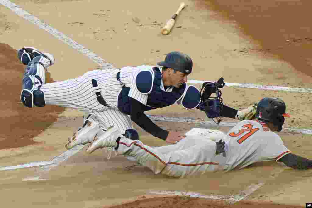 New York Yankees catcher Kyle Higashioka (66) tags Baltimore Orioles Cedric Mullins (31) out at the plate on a fielder&#39;s choice during the first inning of a baseball game, April 6, 2021, at Yankee Stadium in New York.