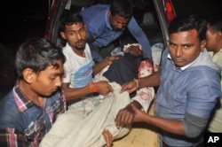 FILE - A man injured in an attack on a Shi'ite mosque is carried for treatment in Bogra district, Bangladesh, Nov. 26, 2015.