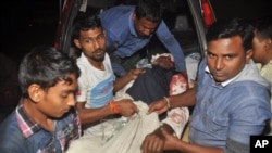 Warga membawa seorang pria yang terluka pasca serangan terhadap sebuah masjid di Bogra, Bangladesh Kamis (26/11).
